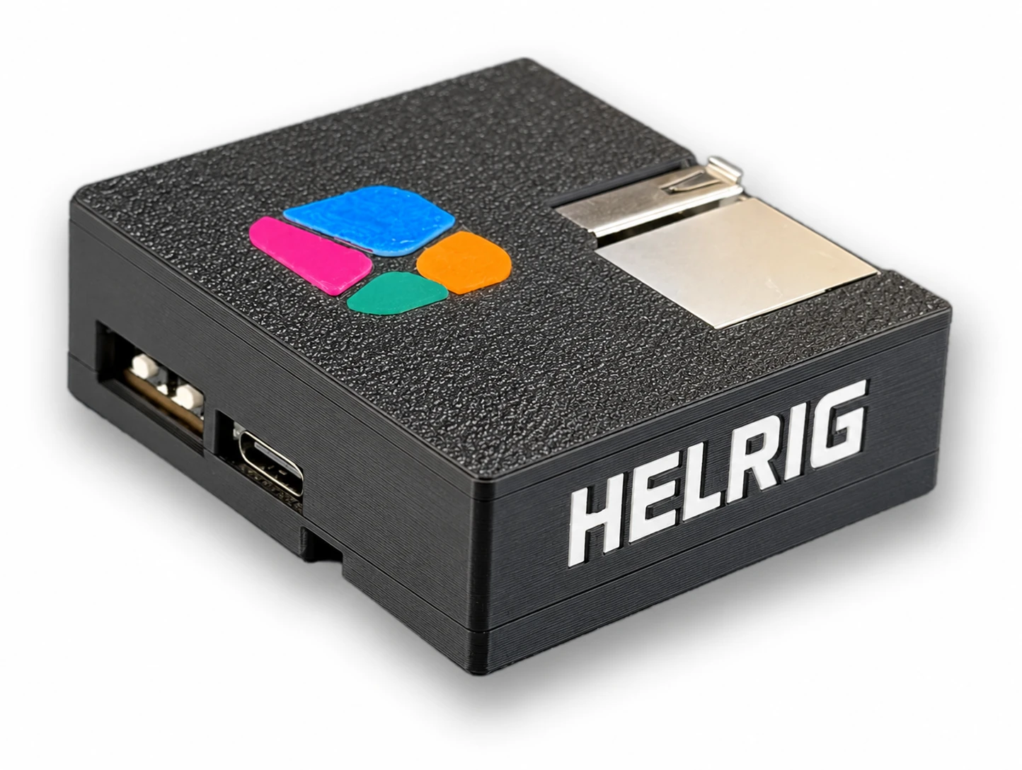The finished Helrig Box: a small black 3D-printed case with the four-colour Helrig symbol on top and HELRIG in white on the side